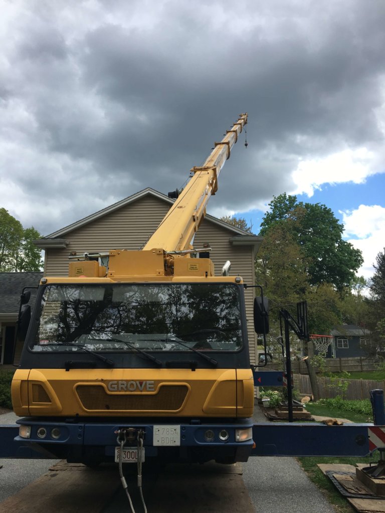 Crane is used in removal of large tree in tight space-Burlington,MA- Middlesex Tree Service